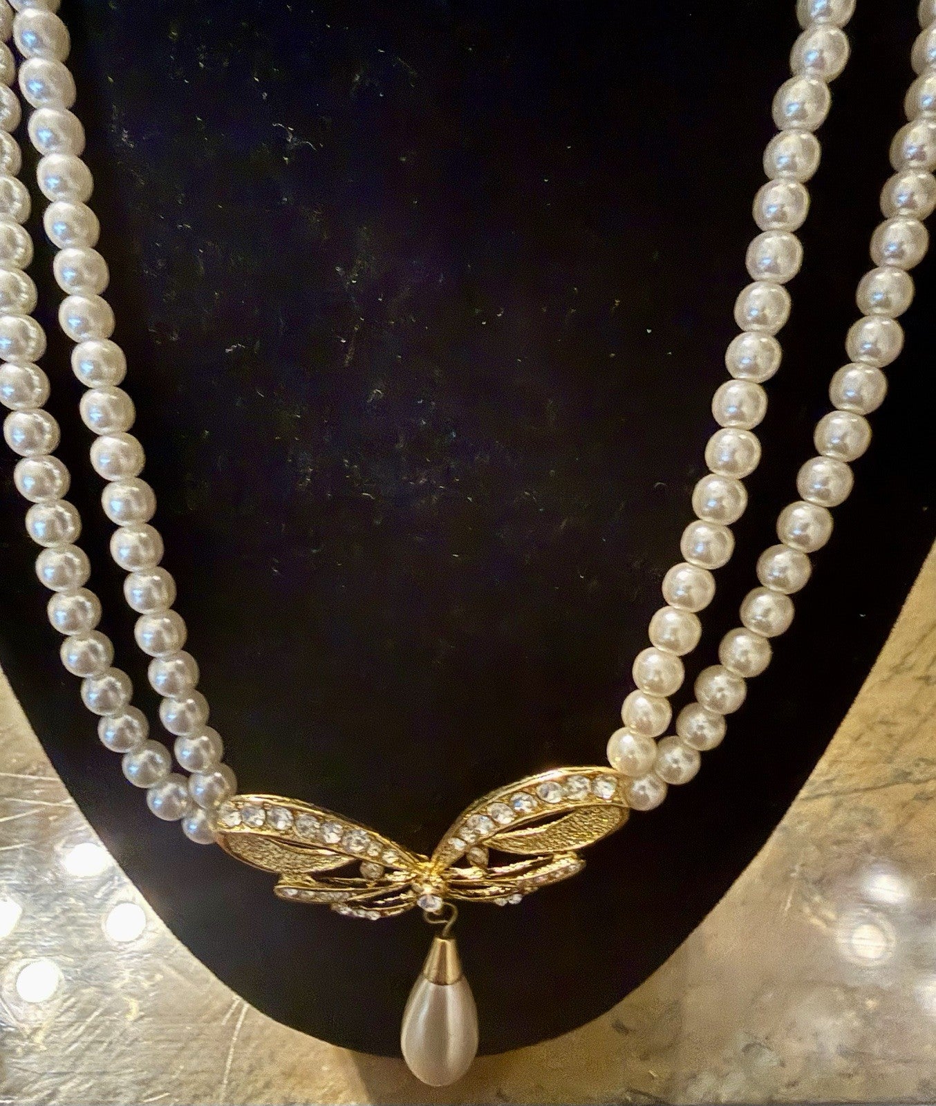 vintage triple-strand faux pearl piece featuring a gold-tone butterfly