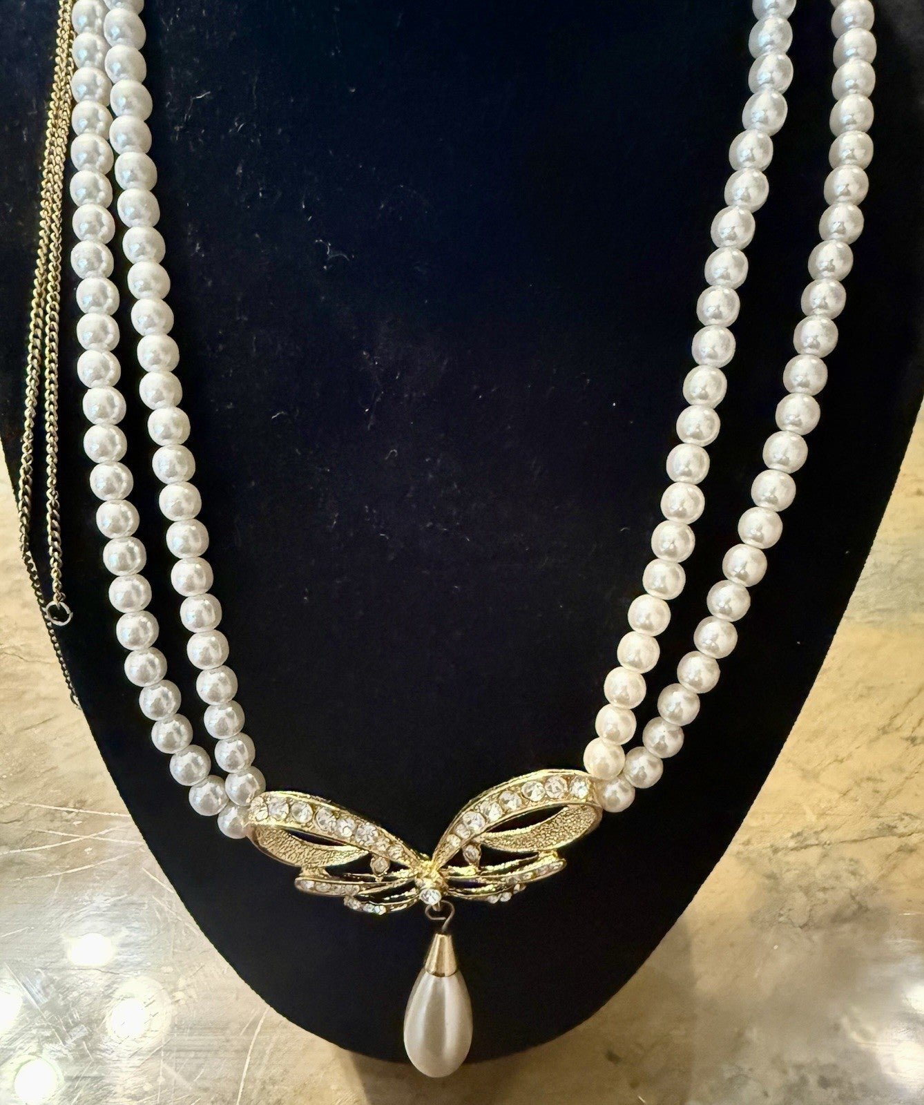 vintage triple-strand faux pearl piece featuring a gold-tone butterfly